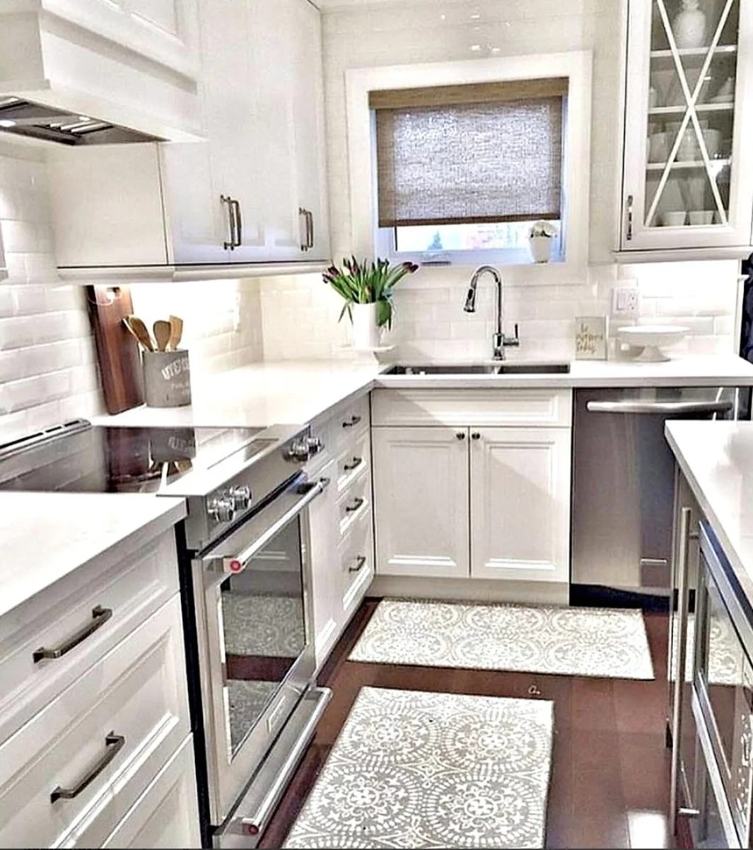 Kitchen With White Cabinets, Brick Walls, And Wood Floors