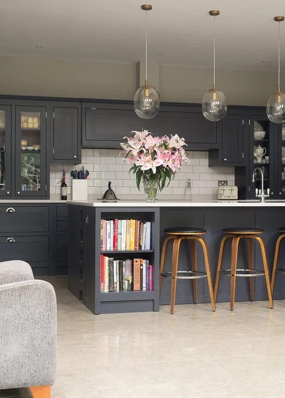 Dark Kitchen Caniets With Glass Light Fixtures And Wood Barstools