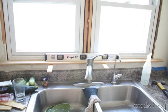 trimming the windows in our white kitchen remodel