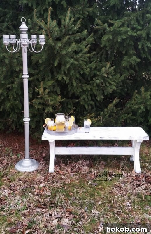 Outdoor farmhouse style bench made from 2x4s, featuring a robust and welcoming design for any porch or patio.