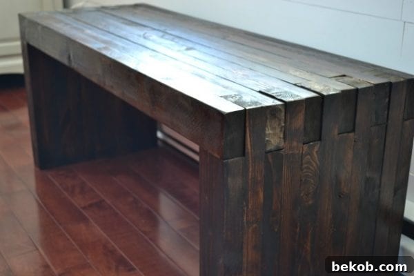 DIY indoor or outdoor dining bench with a stacked wood design, made from 2x4s for a modern aesthetic.