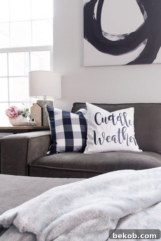 Cozy fall pillow with 'cuddle weather' text made using a Cricut Explore, paired with a buffalo check pillow