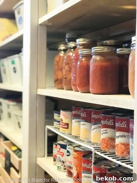 Highly organized pantry shelf with labeled bins and items facing forward