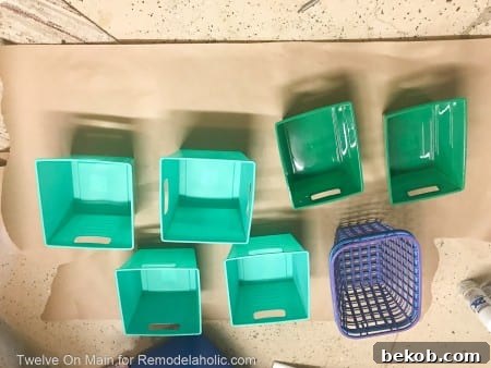 Plastic bins laid out for spray painting in a well-ventilated area