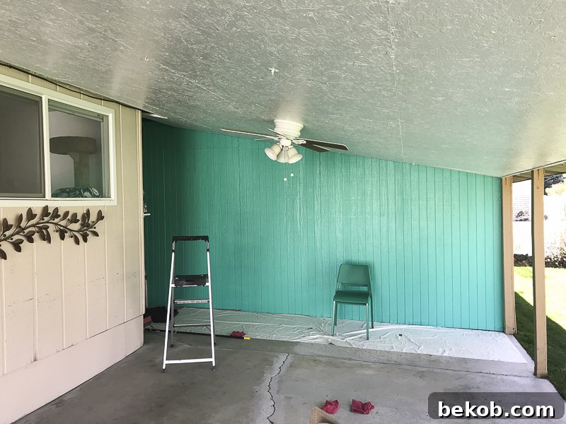 Outdoor Dining Room With IKEA Furniture. A person painting the wall a bright teal color.