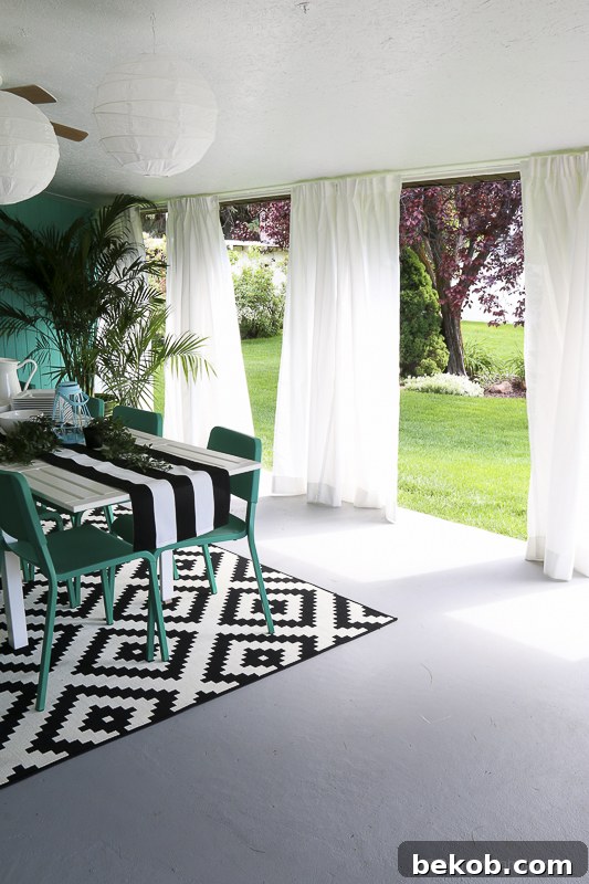 After: Outdoor Dining Room with IKEA Furniture. White curtains and a geometric rug define the elegant space.
