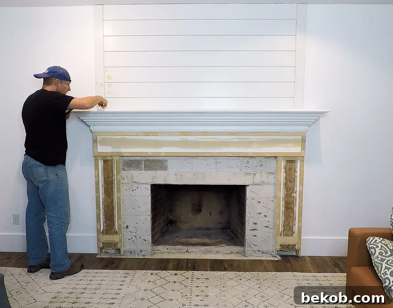 Updated shiplap woodwork around an existing fireplace mantel and surround, pre-paint finish