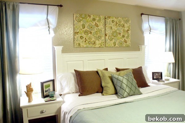 A large piece of DIY fabric art hanging above a bed, made with kitchen cabinet doors.