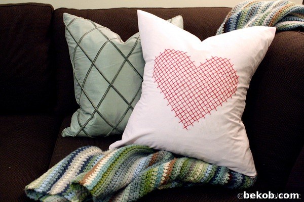 A soft, decorative heart pillow with sweet embroidered details.