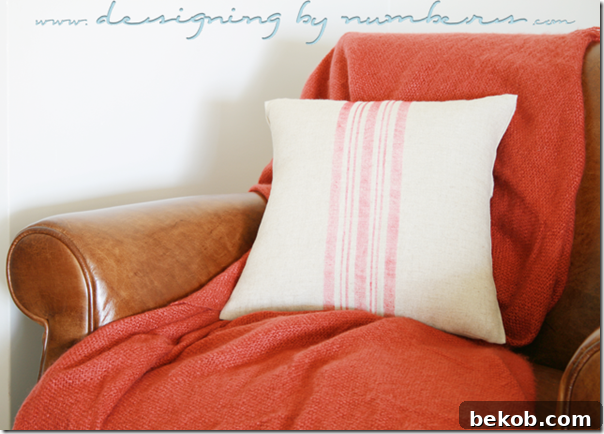 A stylish grain sack pillow resting comfortably in an armchair.