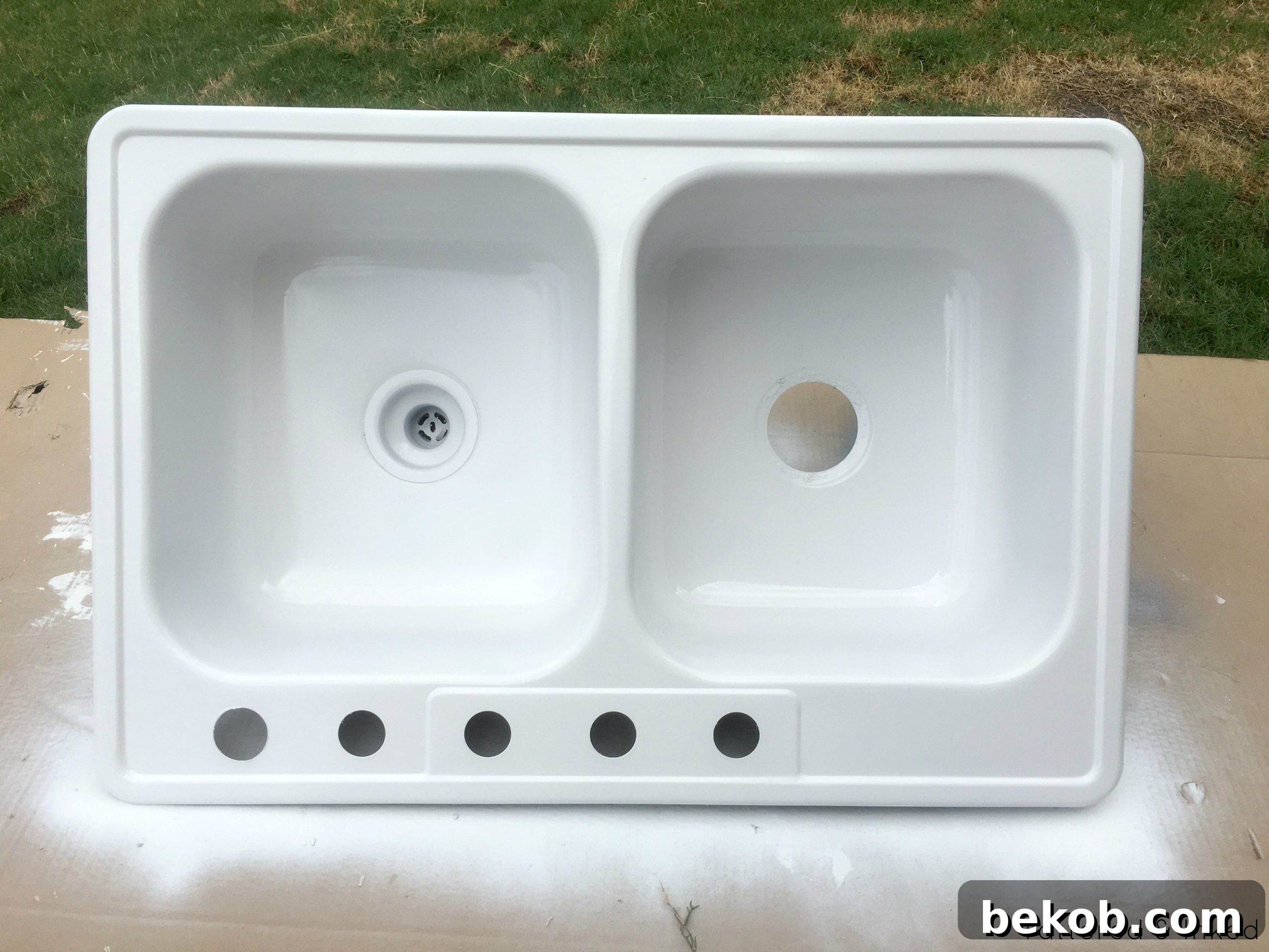 A repurposed sand and water table, ingeniously made from an old kitchen sink, perfect for children's outdoor play.