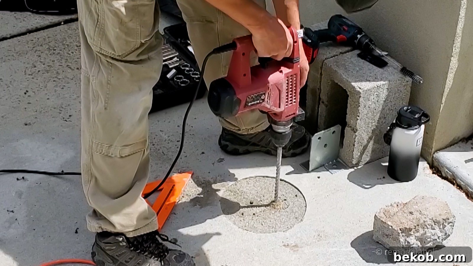 Drilling holes into concrete for attaching post bases.