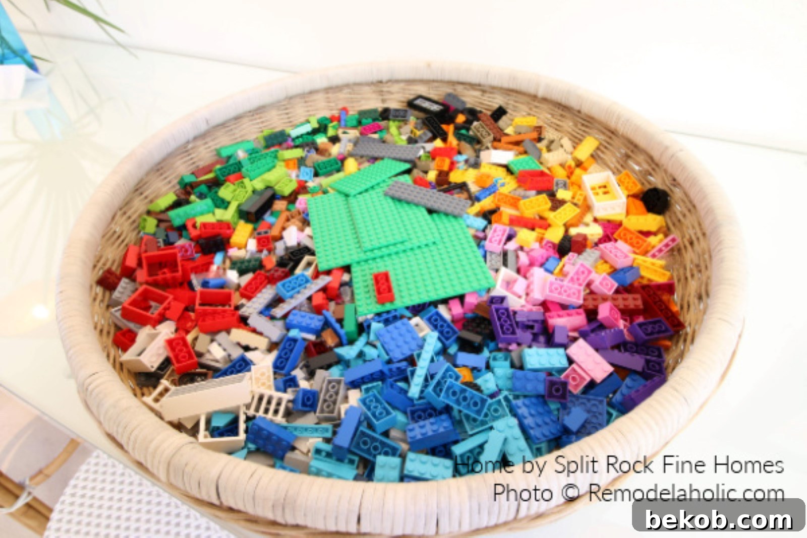 Colorful Lego blocks neatly stored in a stylish woven basket in a living room, demonstrating decorative yet practical toy storage solutions for small spaces.