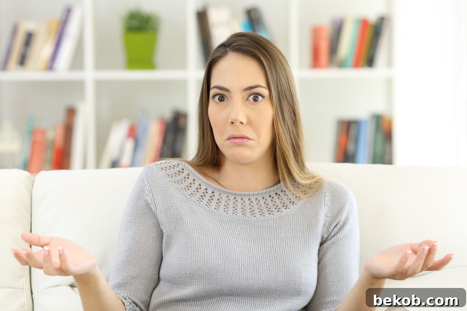 Confused woman looking frustrated while trying to balance minimalist decor elements, representing the challenge of making a space both simple and inviting.