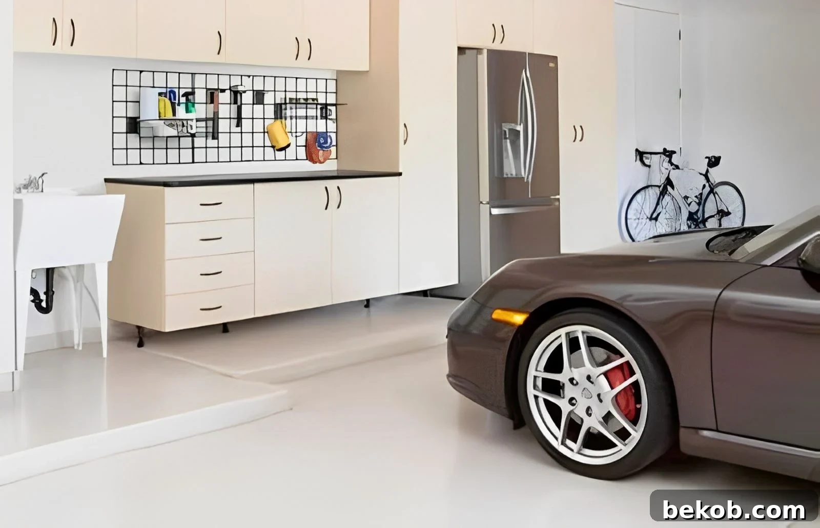 A neatly organized garage with light-colored walls, cabinets, and a gray floor, offering garage organization ideas.