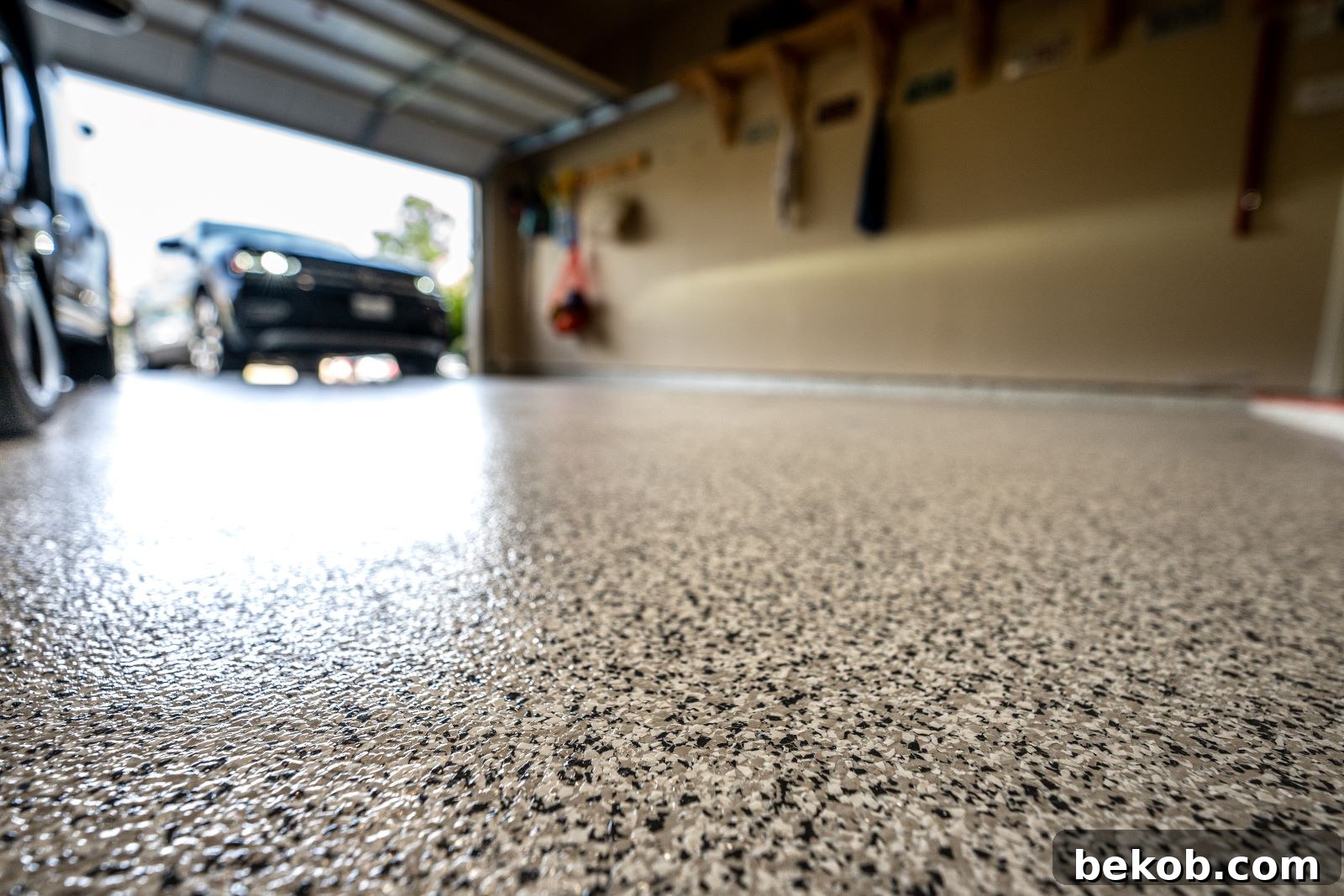 Close-up of a glossy, grey epoxy floor in a garage, highlighting durability and easy cleaning as flooring options for a remodel.