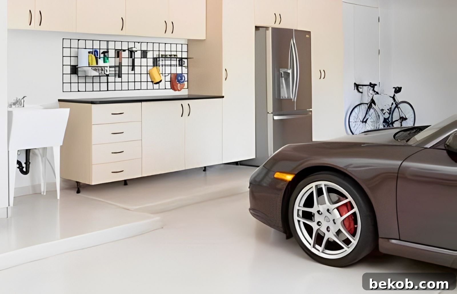 A neatly organized garage with light-colored walls, cabinets, and a gray floor, illustrating effective garage paint colors and design.