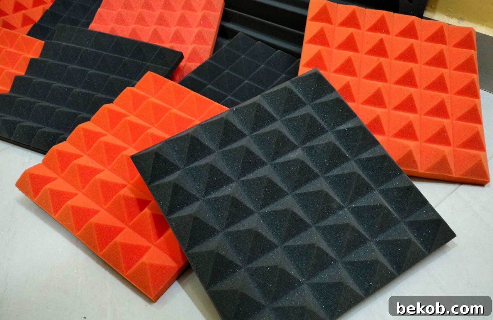 A wall covered with dark soundproof tiles in a garage setting, illustrating sound insulation for a quiet garage space.