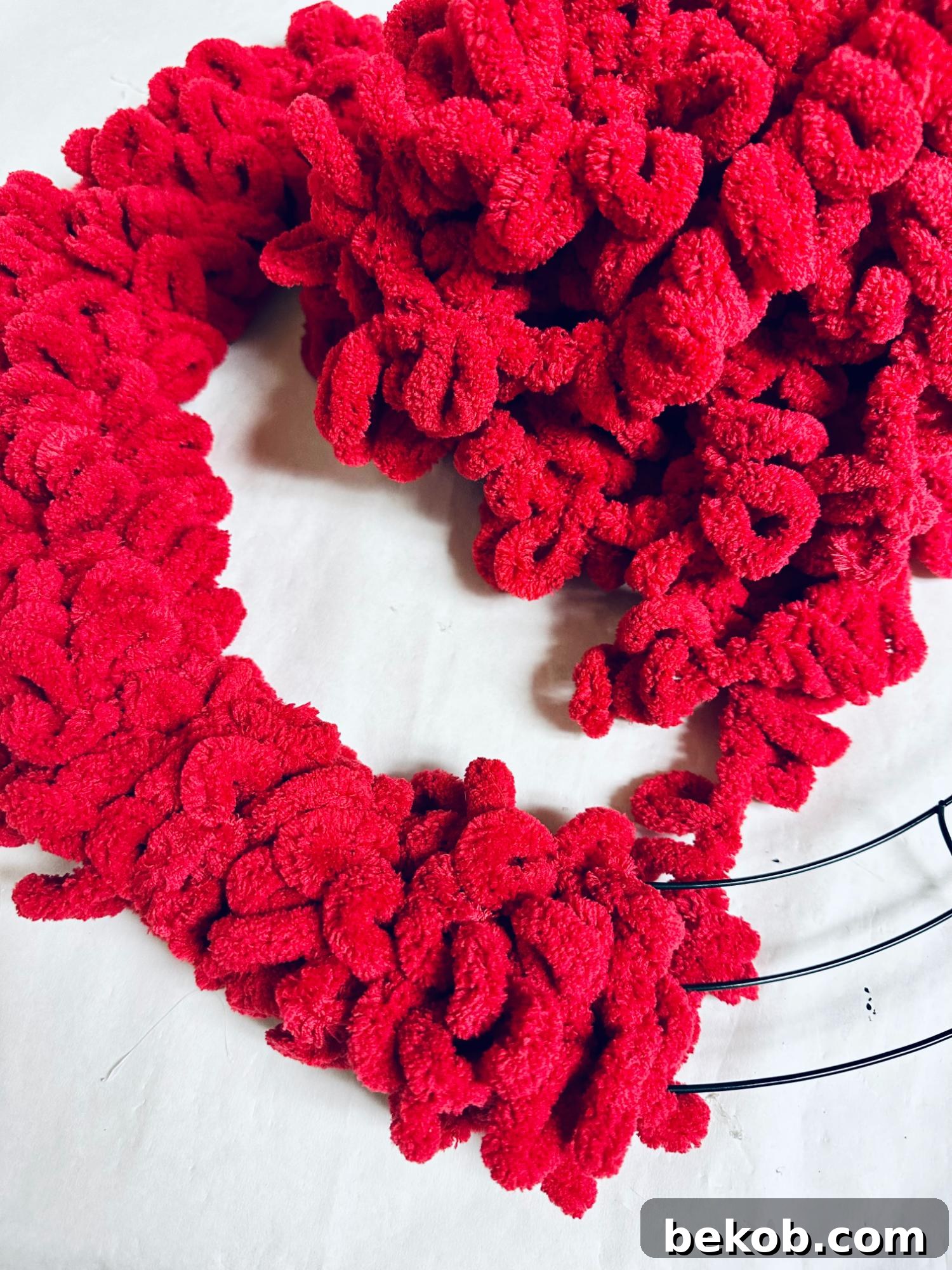 Wrapping the loop yarn around the wreath form for a full finish