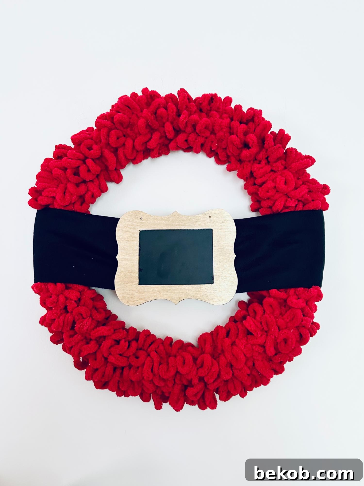 Securing the ends of the black fleece scarf to the back of the wreath