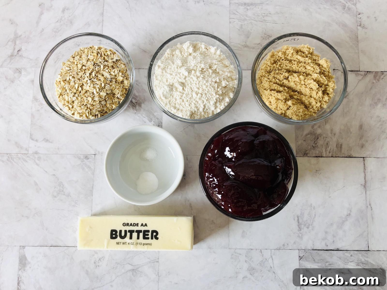 Layout of ingredients for Raspberry Oatmeal Bars, including oats, flour, sugar, butter, and raspberry jam.