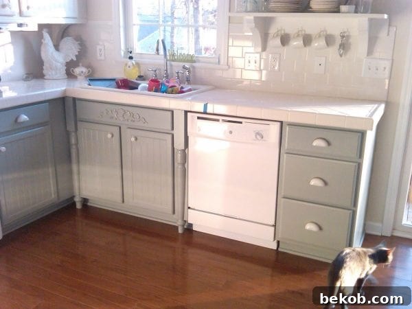 Kitchen renovation progress: oak cabinets painted white and gray, showcasing new countertops