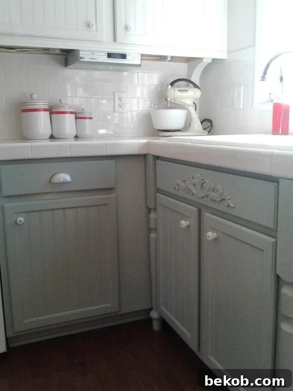 Close-up of updated kitchen cabinets, oak transformed to gray paint with milk glass knobs, Benjamin Moore Silver Mink