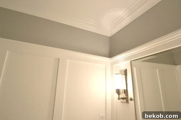 After view of elegant powder room with wainscoting and crown molding