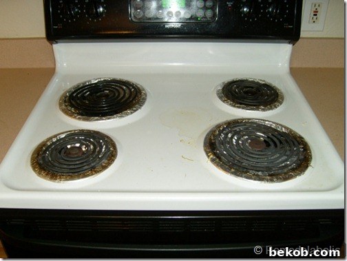 The original kitchen range, a mix of black and white, appearing dated and unclean.