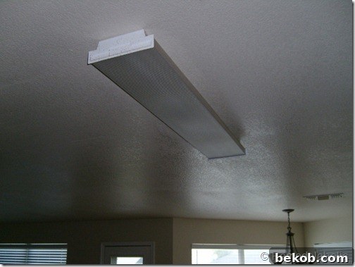 A single fluorescent ceiling light fixture in the original kitchen, demonstrating inadequate lighting for the space.