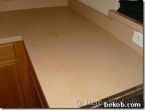 Close-up of the kitchen cabinets and stained countertop, showing the wear and tear of the original kitchen.