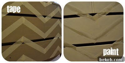 Close-up of chevron stripes being painted on furniture with painter's tape