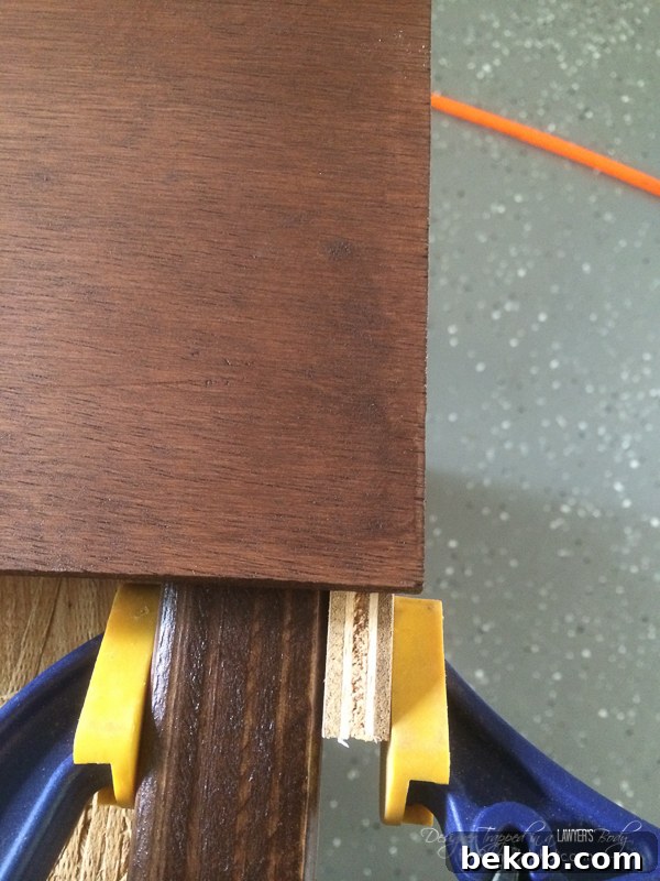 DIY Utility Box Cover - Wood Screen for the Side of the House Eyesores. This image shows the front slats being attached to the vertical supports with a brad nailer, demonstrating the overhang for side panels.