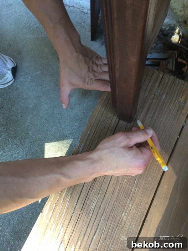 DIY Utility Box Cover - Wood Screen for the Side of the House Eyesores. This image shows the process of tracing and cutting out notches in stairs to accommodate the screen's vertical supports.
