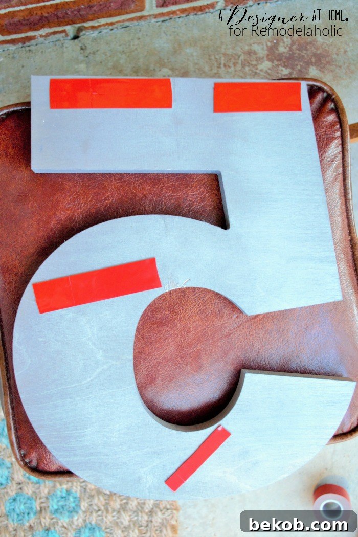 Using heavy-duty outdoor double-sided tape for a clean, drill-free installation of large house numbers on your home's exterior.