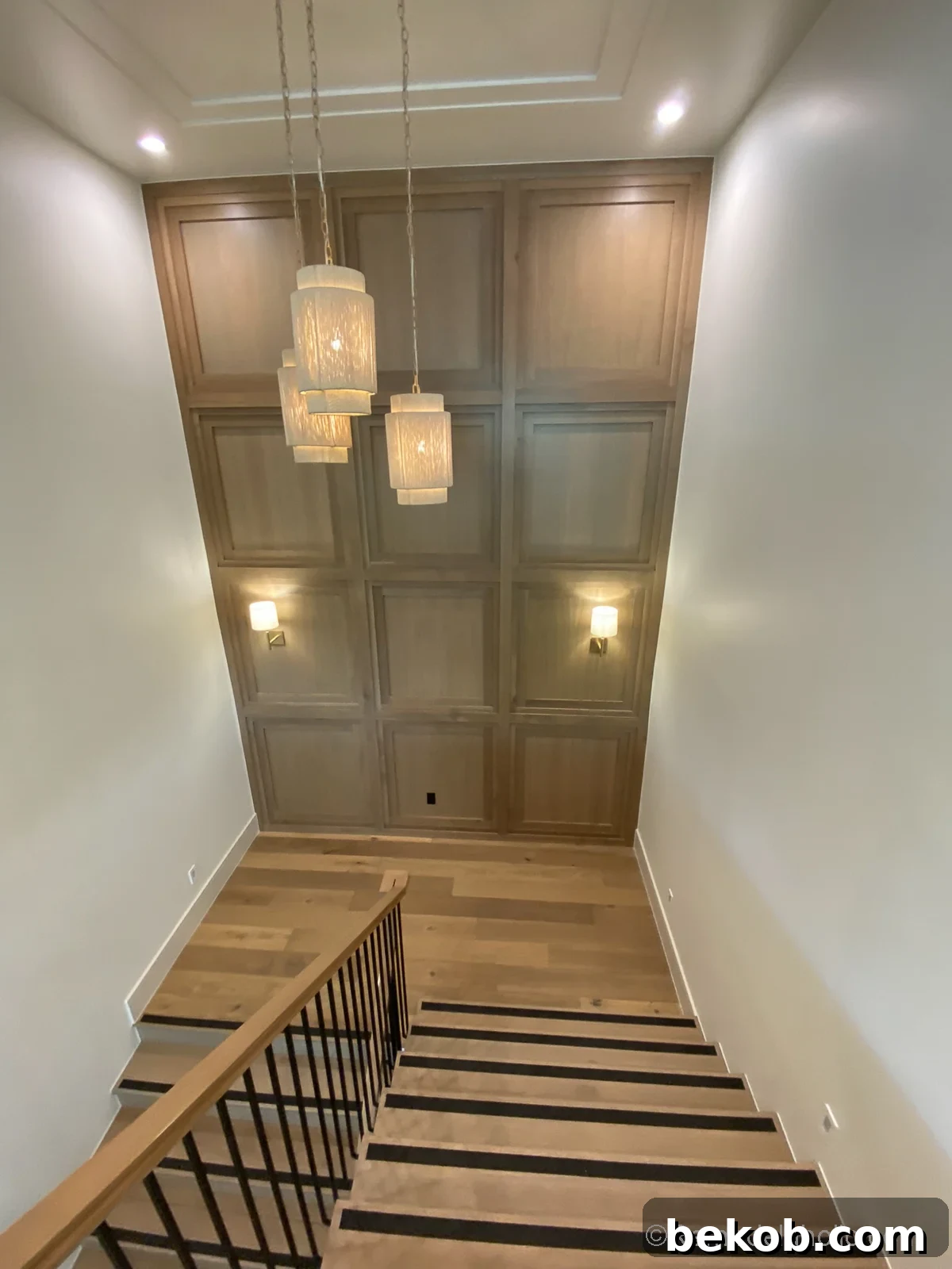 Tall accent wall in stairs using millwork molding's of stained wood