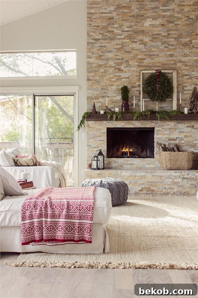 Uncentered fireplace with stone surround, cozy seating, and festive Christmas mantel