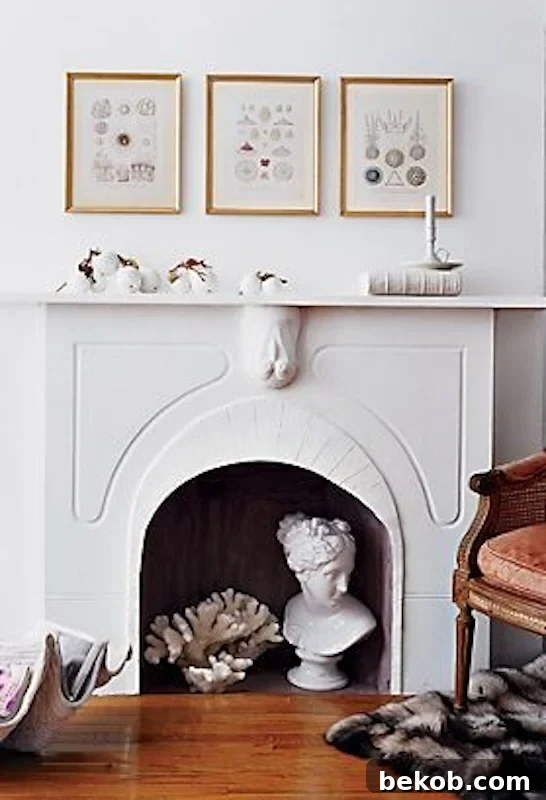 Stunning white fireplace with delicate gold frames, elegant bust, and coral decor