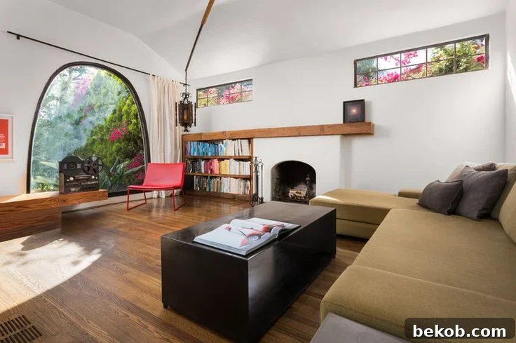 Asymmetrical fireplace and mantel complemented by modern furniture and a built-in bookcase