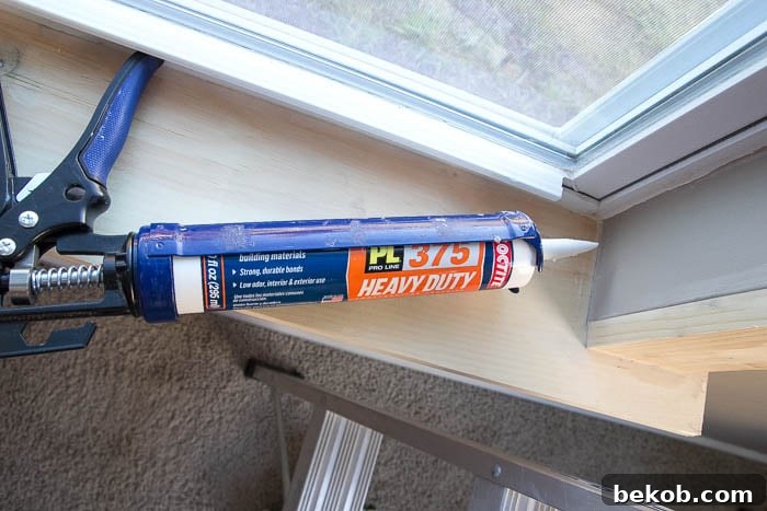 Caulking the seams of the window trim