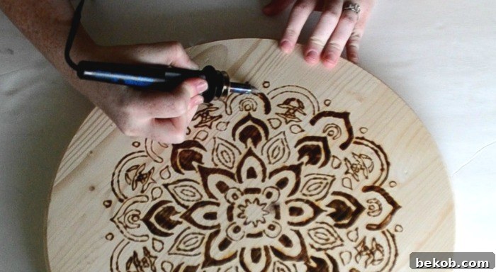 Shading with a wood-burning tool on the mandala stenciled design