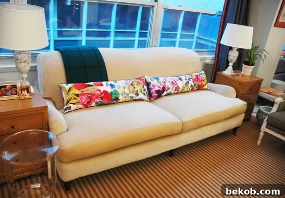 Neutral sofa adorned with long, floral lumbar pillows, adding color and visual interest.