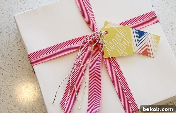 Gift box wrapped in white paper with ribbon and layered printable gift tags
