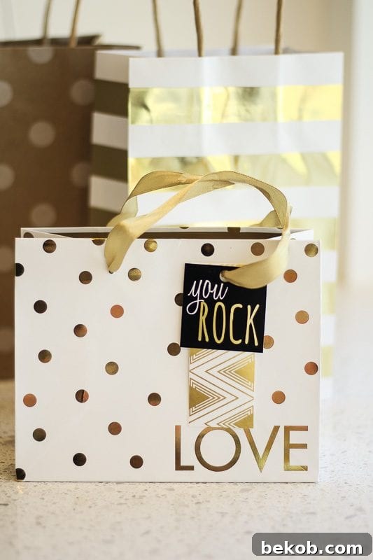 Two hands holding a beautifully wrapped gift with a printable gift tag saying 'You Rock'