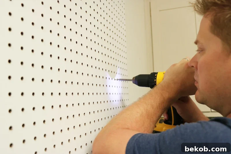 Adding additional screws to the pegboard, ensuring maximum attachment to the furring strips and wall studs.