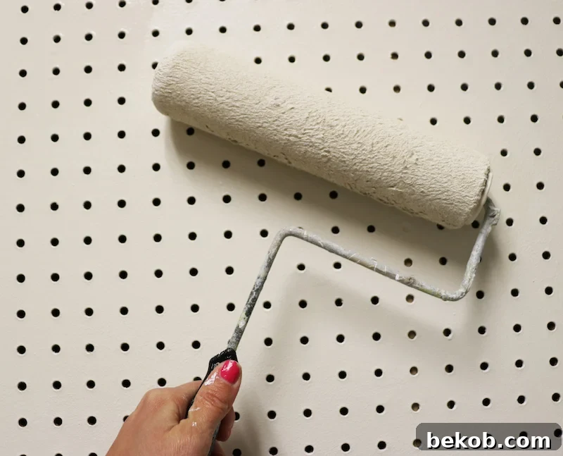 Applying primer and paint to the pegboard for a clean, finished, and integrated look.