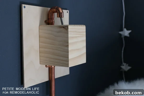 Make this industrial modern, apartment friendly DIY wall sconce with the simplest of materials!
