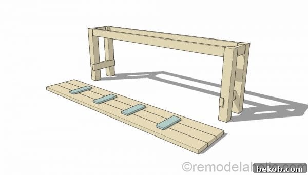 Detailed view of attaching the 1x4 braces to the underside of the 2x6 tabletop planks, forming the sturdy top structure of the no-nails console table. Plans by @Remodelaholic