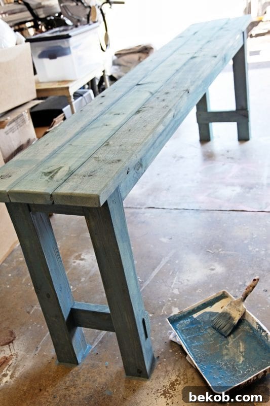 How to use watered down milk paint to get a beachy look on newly built DIY no-nails console table by Shabbyfufu featured on @Remodelaholic