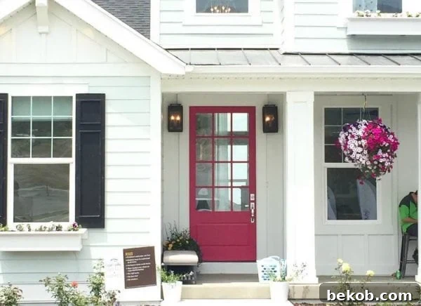 A vibrant home with a fun lipstick pink front door, showcasing excellent curb appeal and a modern aesthetic that makes a statement.